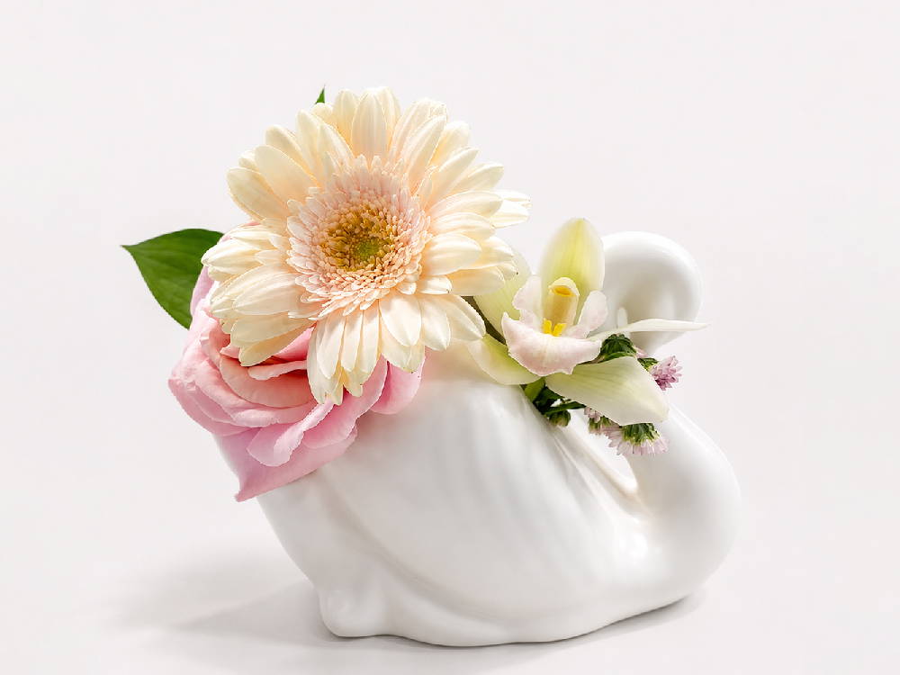 Crown Lynn Swan, ivory, with a floral bouquet An ivory Crown Lynn Swan vase filled with a floral arrangement. By Crown Lynn Kiwi